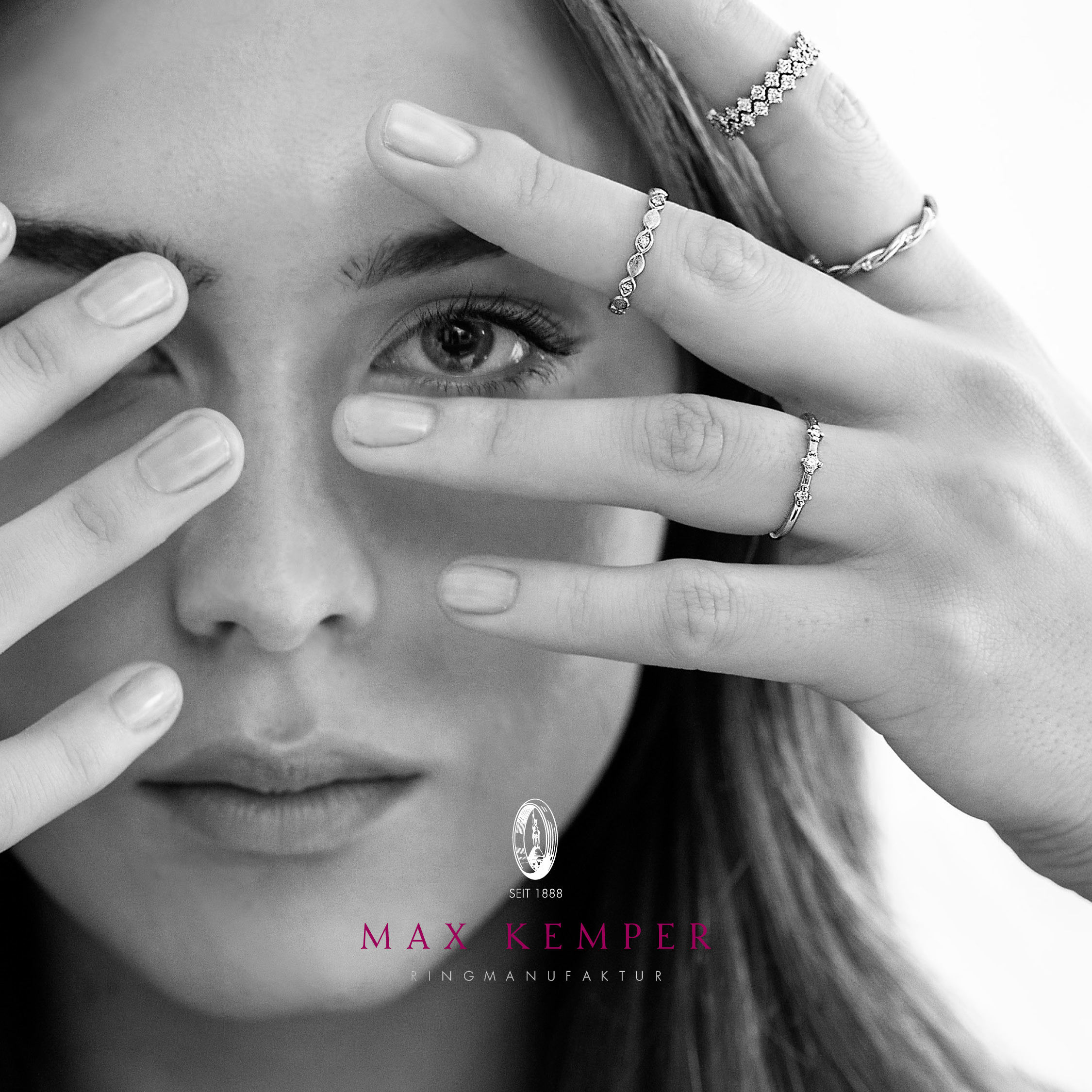 Frau hÃ¤lt Hand mit mehreren Ringen vor ihr Gesicht